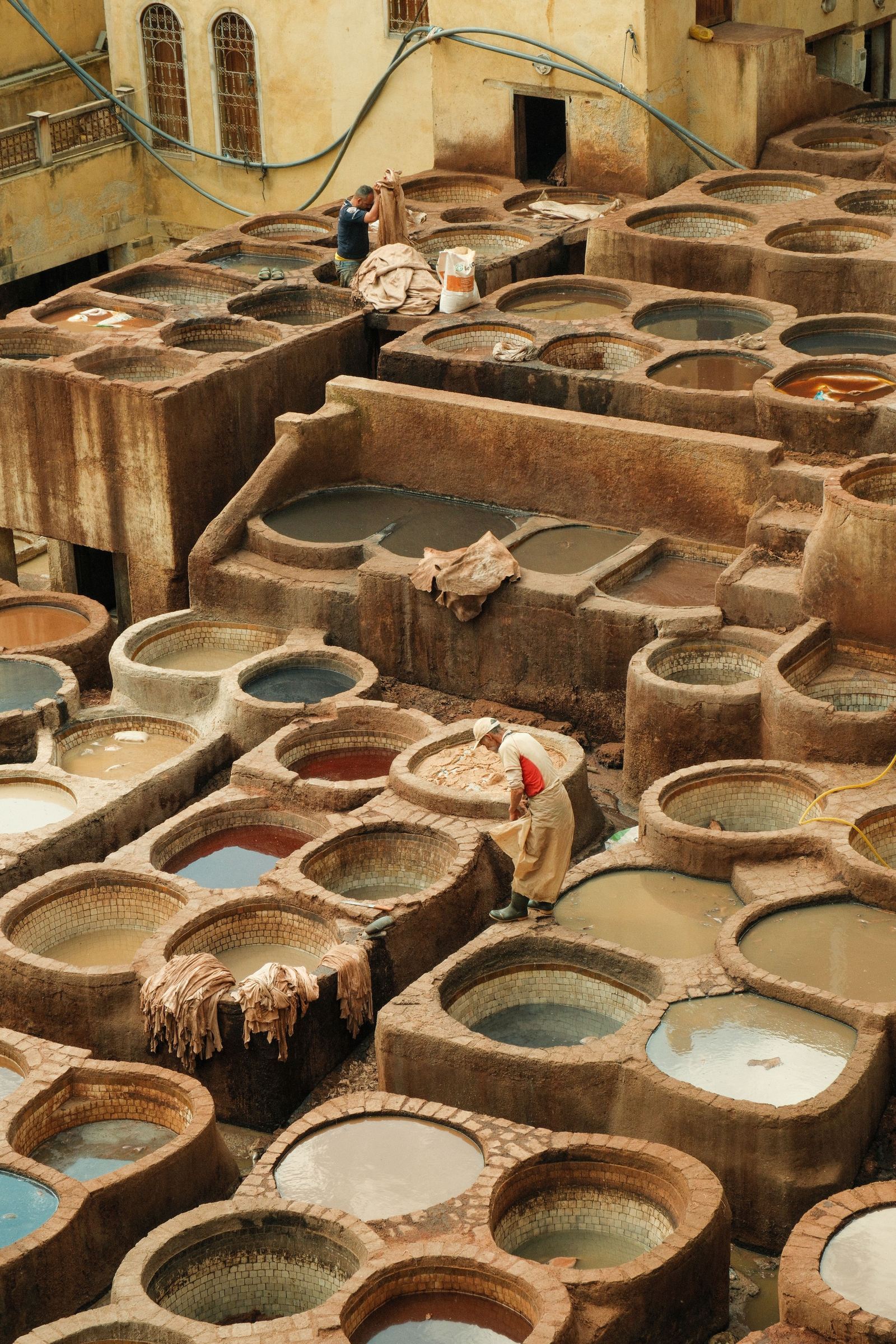 Vista aérea das cubas coloridas de uma curtição tradicional em Fez, Marrocos, mostrando o processo artesanal de tingimento do couro