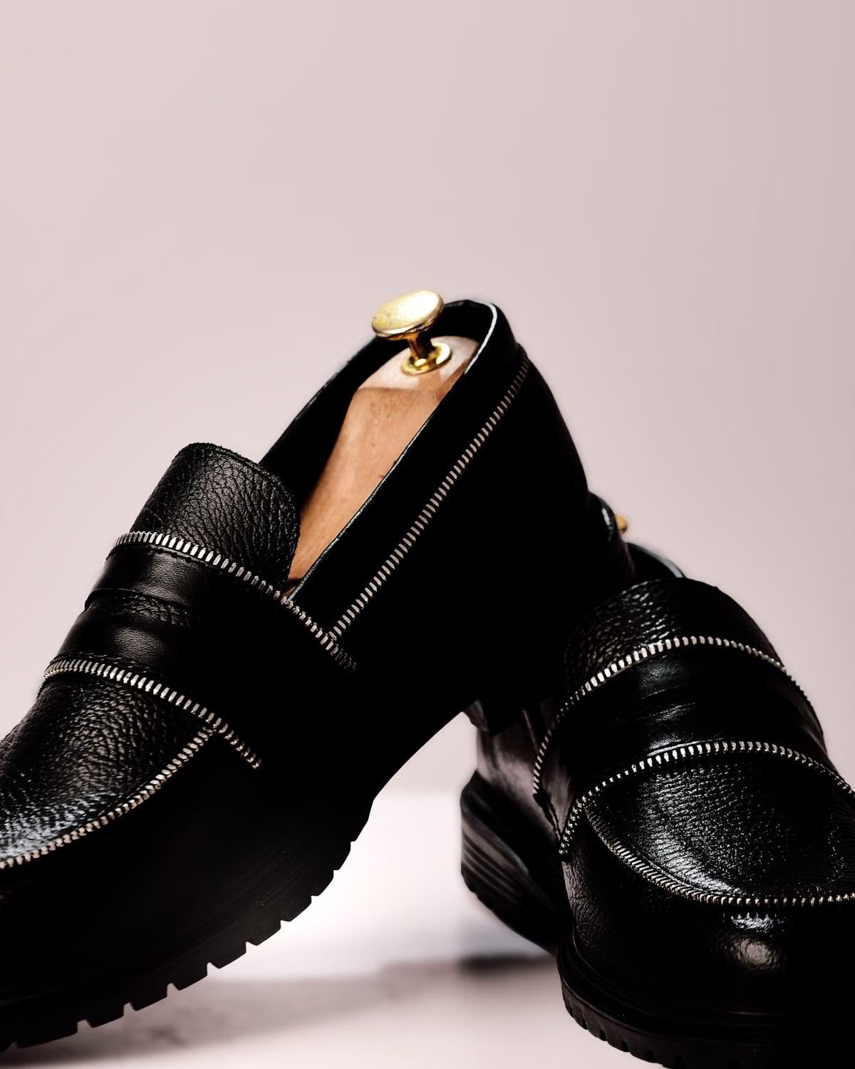 Mocassim de couro artesanal em fundo neutro, destacando a costura característica do modelo