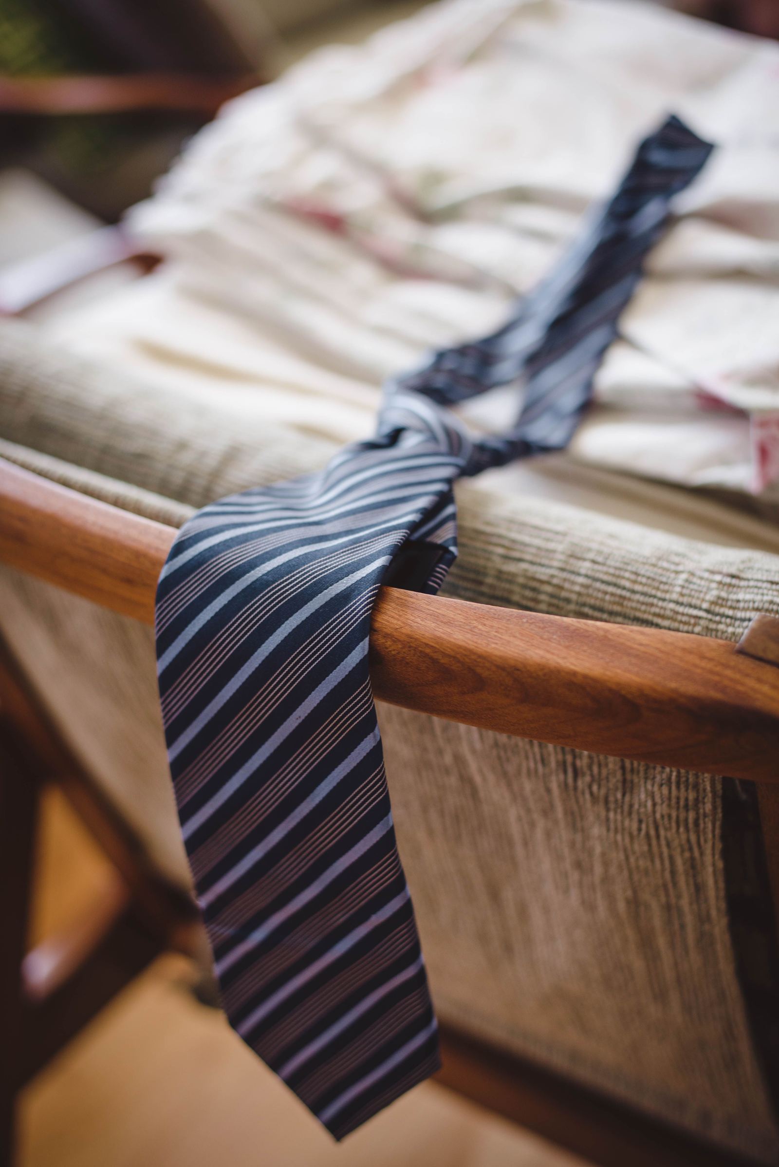 Gravata de seda em tom escuro, bem alinhada sobre camisa social, em estilo clássico