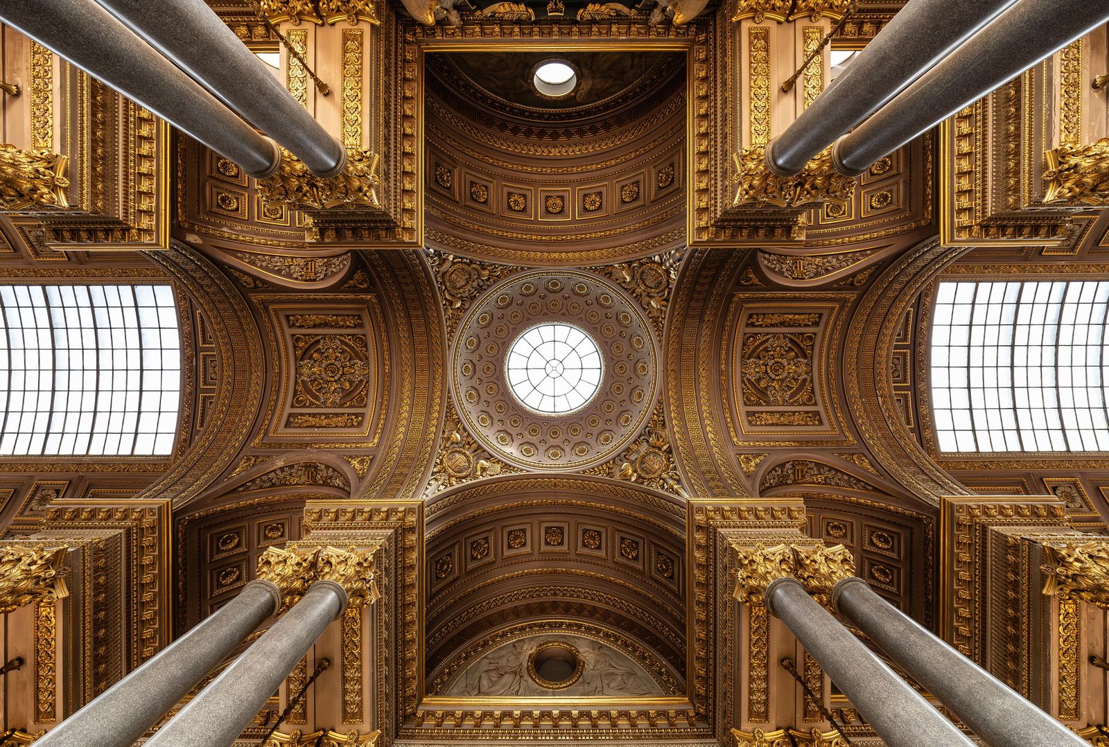 Teto ornamentado em dourado do Palácio de Versalhes, com colunas e detalhes barrocos que remetem ao esplendor da corte francesa